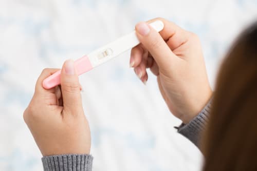 woman looking at a pregnancy test.