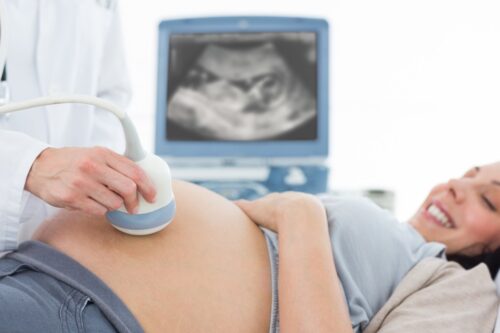 Pregnant teenage girl receiving an ultrasound. 